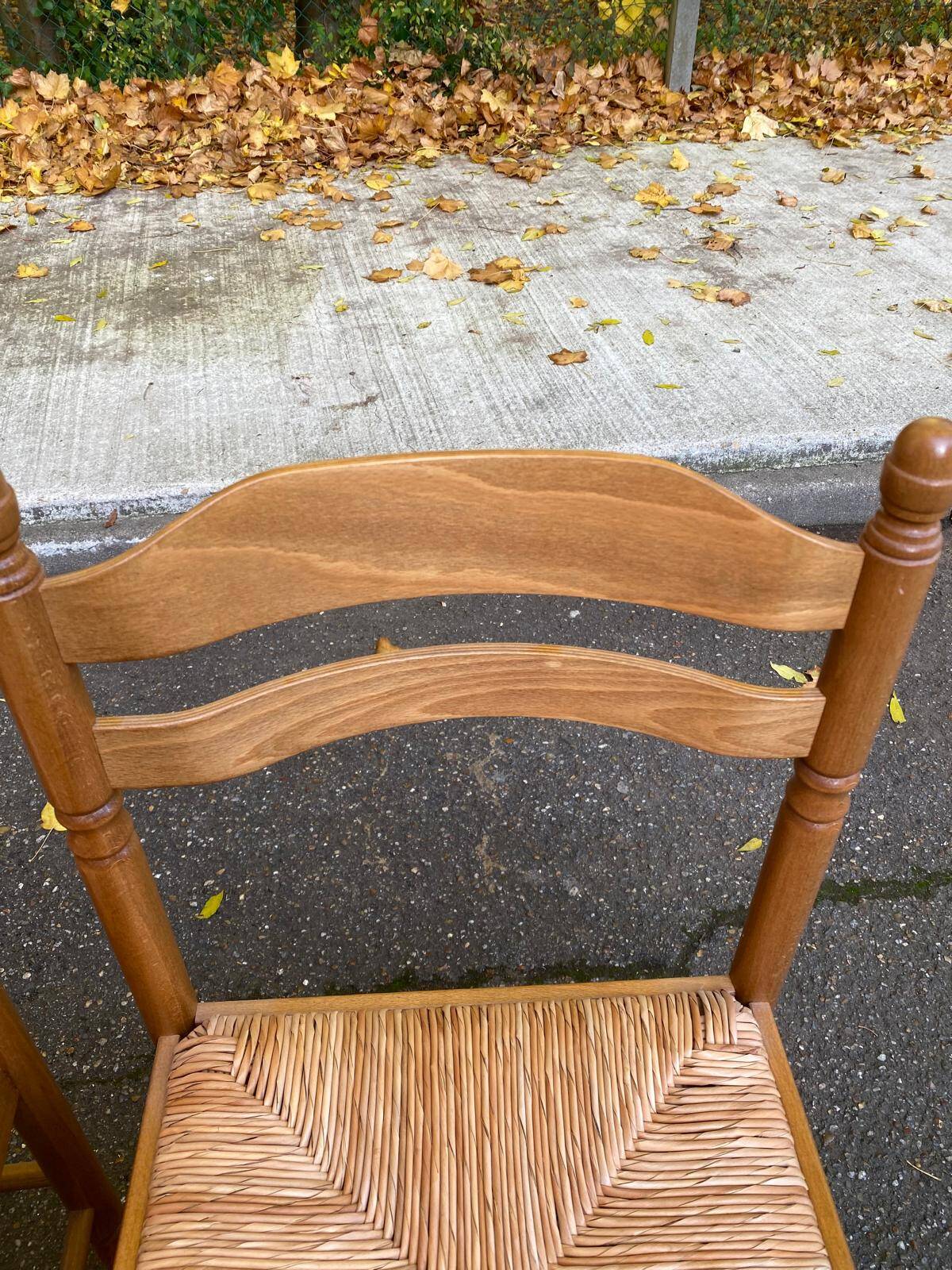 2 solid light wood straw-seated chairs