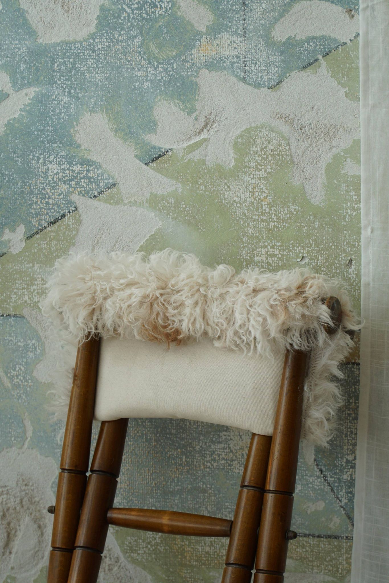 Folding stool, reupholstered in long-haired sheepskin, mid-century modern style, 1950s.