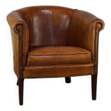 Neat and subtle sheepskin club chair, finished with decorative studs and a fixed seat cushion
