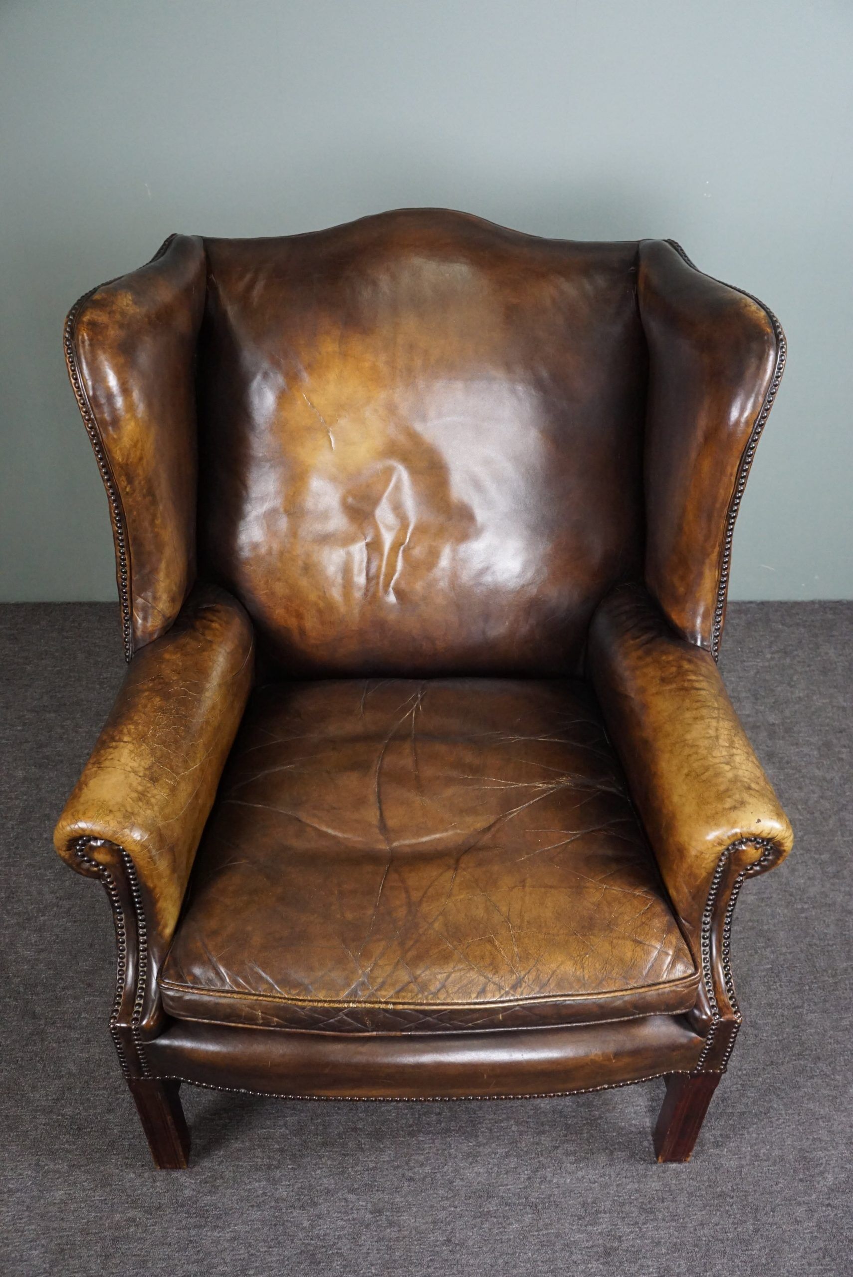Patinated cowhide leather armchair