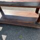 Carved wooden console table with three shelves and drop-leaf flap