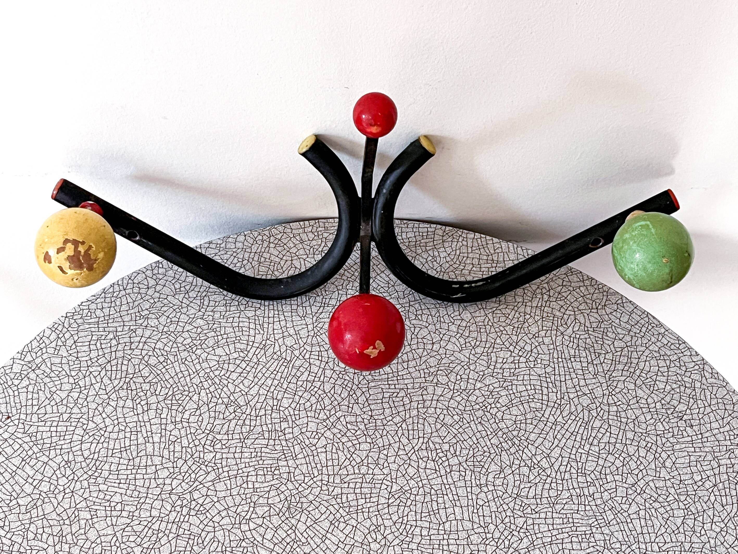 Vintage metal and wood coat rack in yellow/red/green.