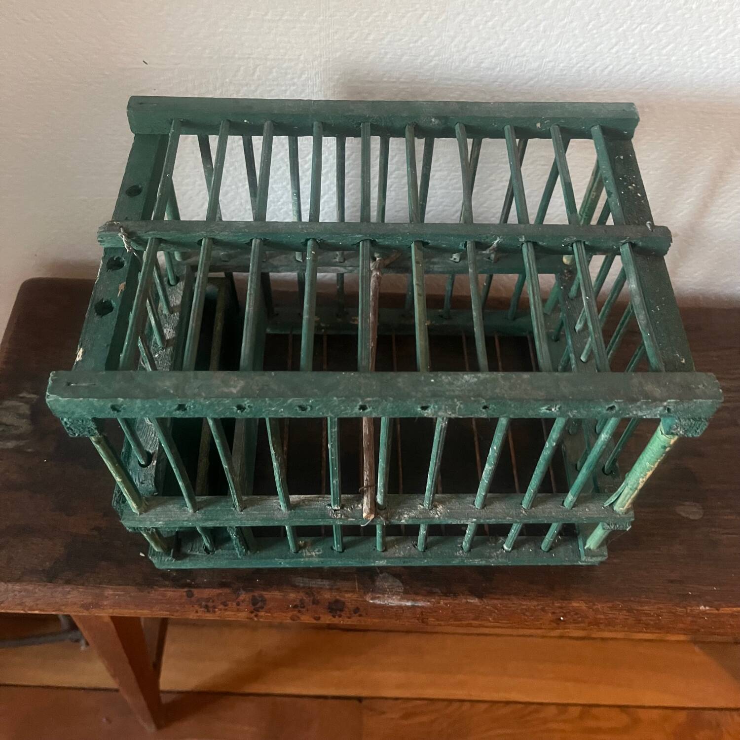 old bird cage made of wood and painted green