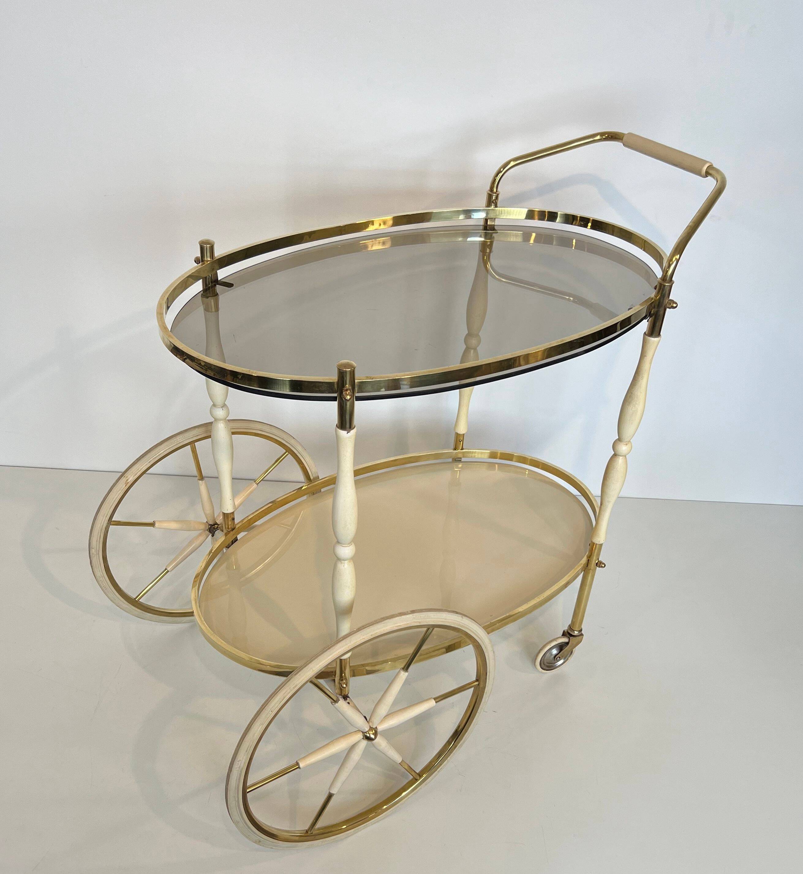 Italian oval rolling table in brass and lacquered wood.