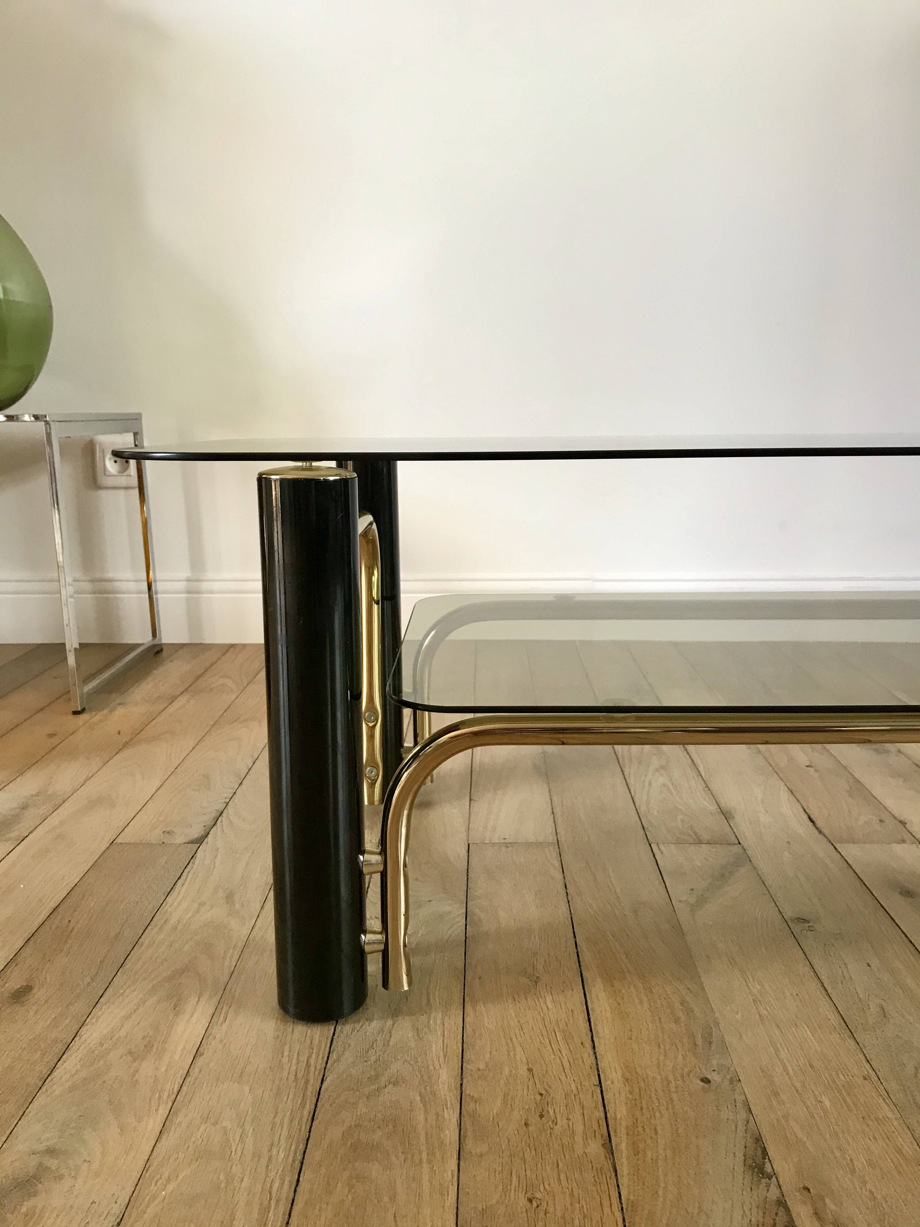 coffee table in smoked glass and black and gold metal from the 70s