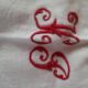 Ancient damask tablecloth. Surroundings borders red. Red central monogram.