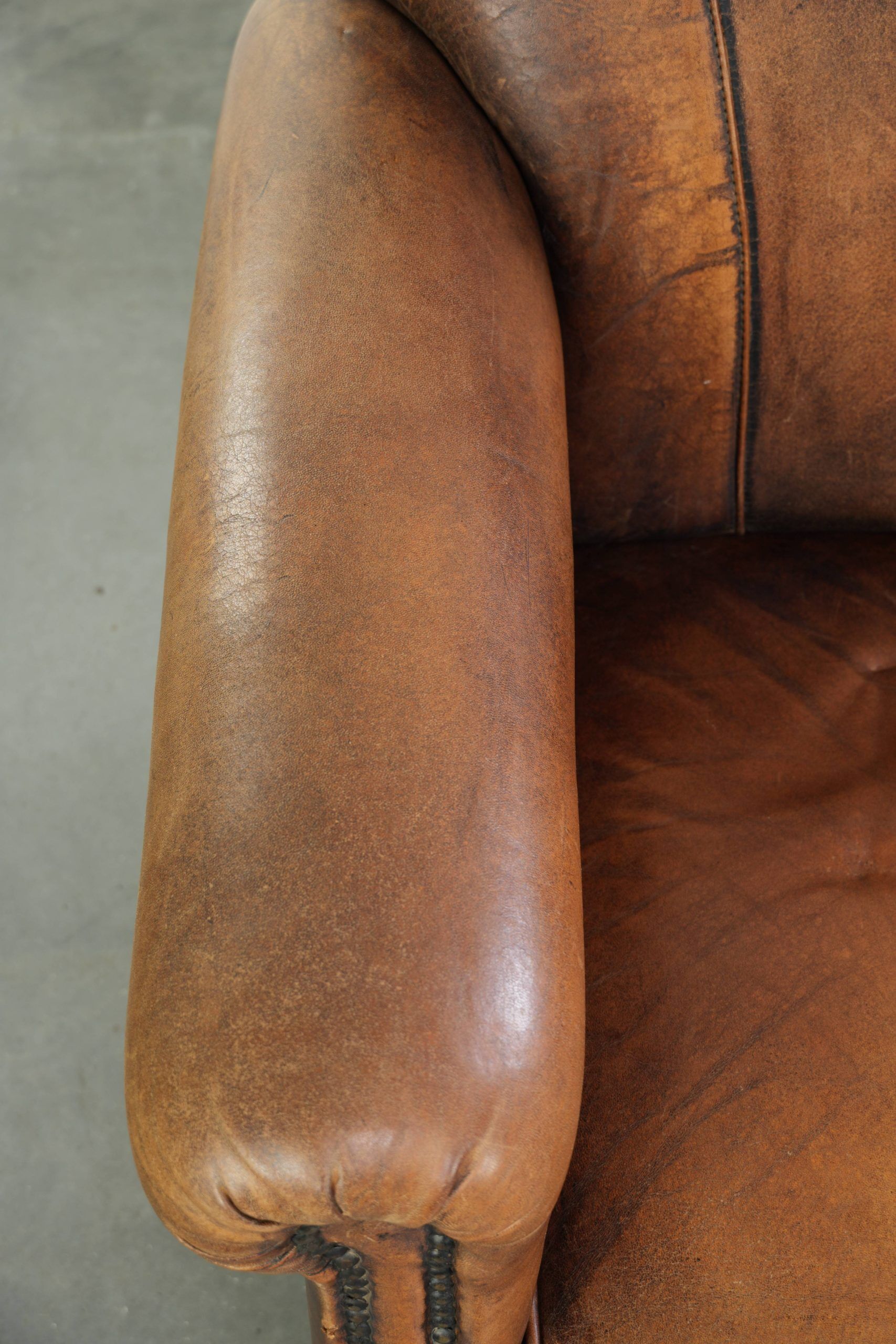 Comfortable characterful sheepskin armchair finished with decorative nails