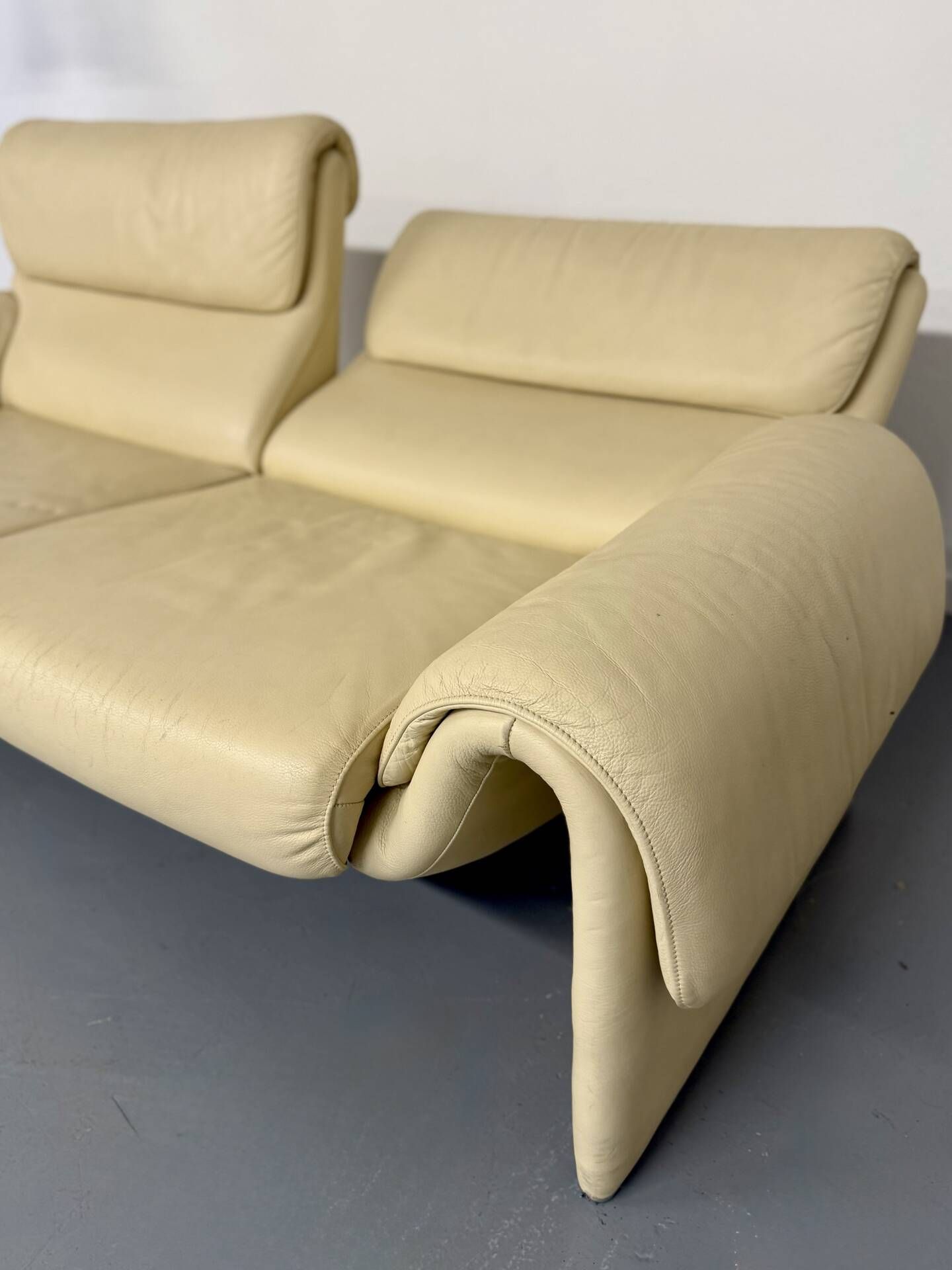 Two-seater designer sofa De Sede DS-2011 in cream leather with adjustable backrest.