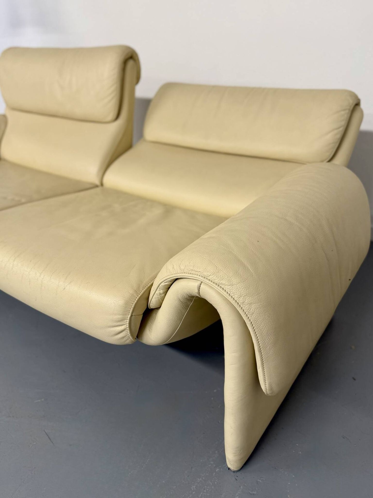 Two-seater designer sofa De Sede DS-2011 in cream leather with adjustable backrest.
