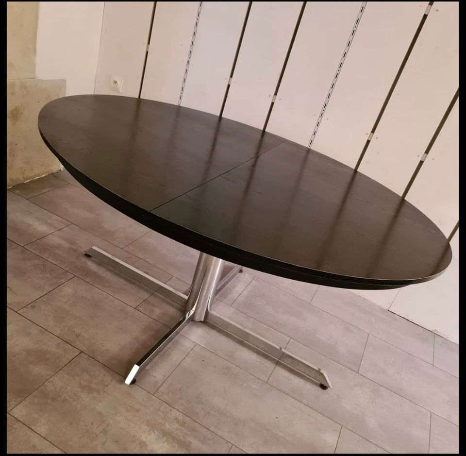 Blackened wooden dining table and chrome foot with integrated butterfly extension