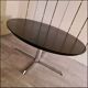 Blackened wooden dining table and chrome foot with integrated butterfly extension