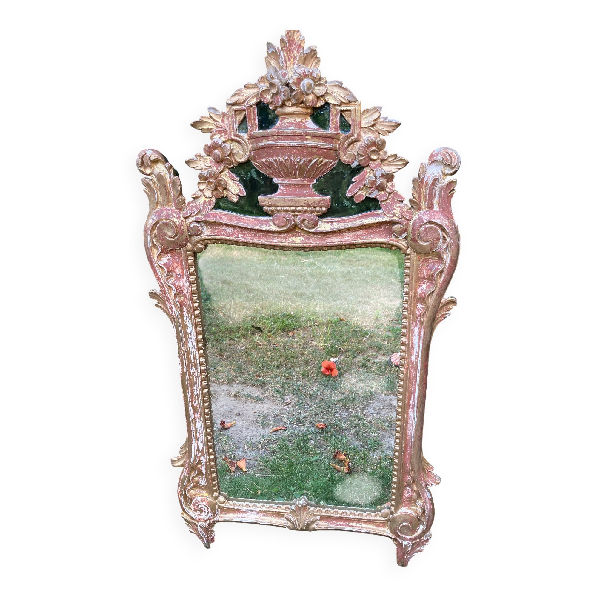 Mirror above a wooden and gilded stucco fireplace in the style of the 18th century.