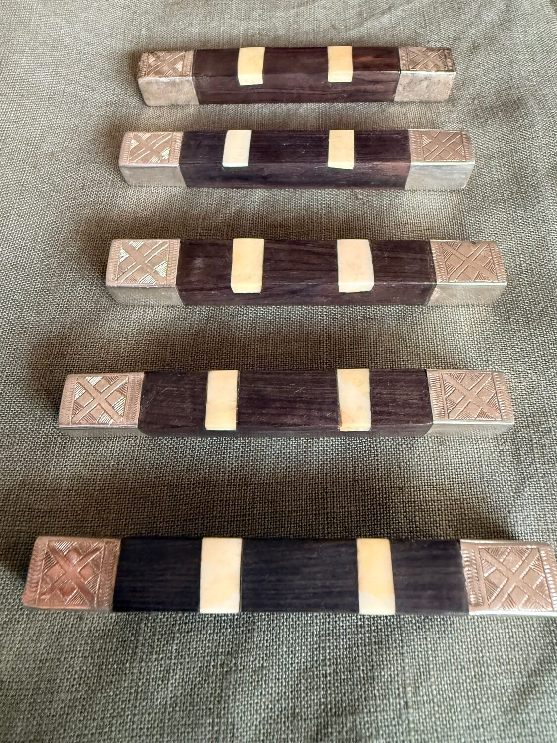 Lot 11 knife rests in ebony and silver-plated metal.