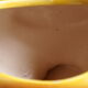 Ceramic watering can in white earthenware, yellow enamel and bird shape