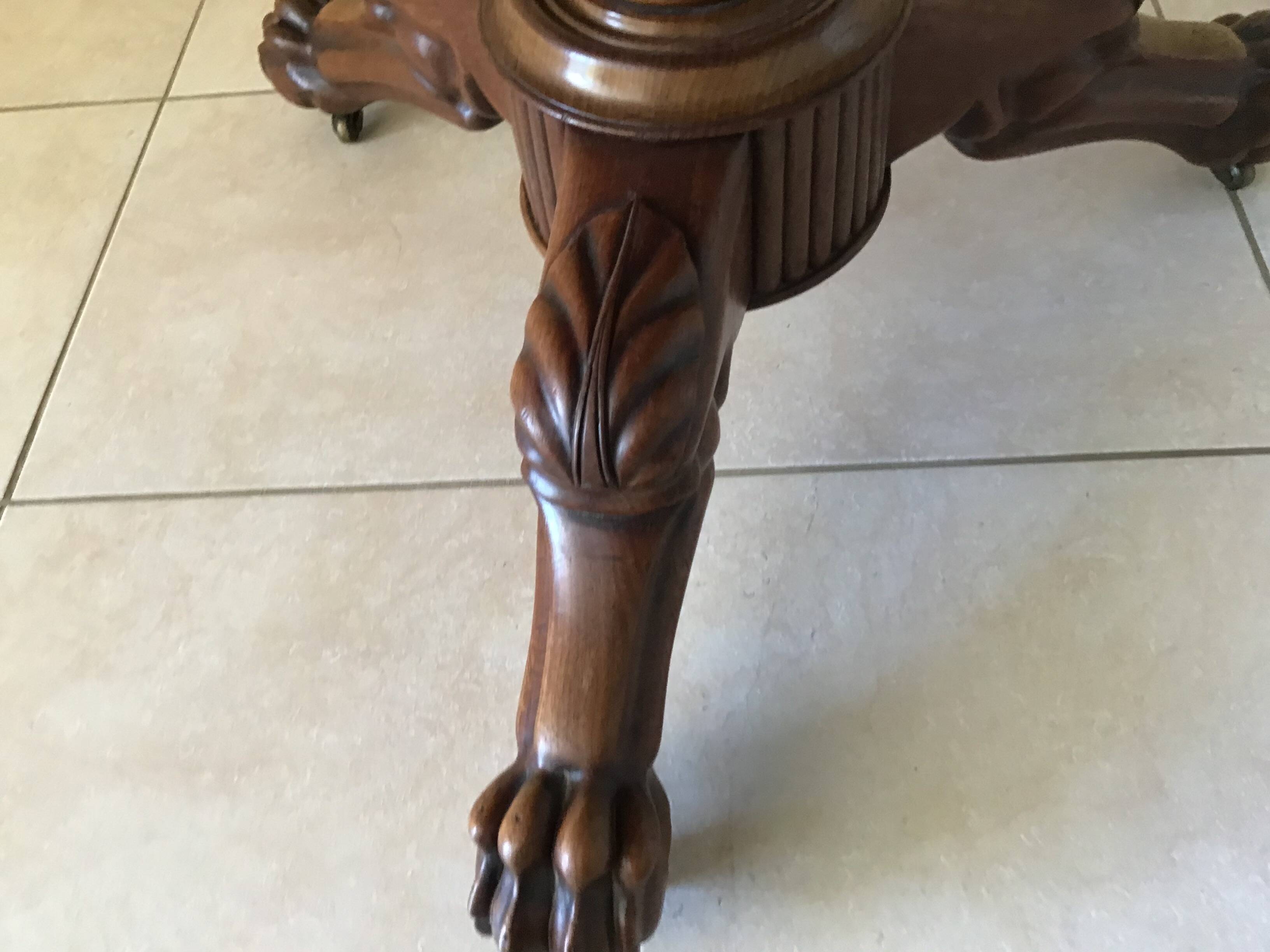 Wooden gueridon with marble, lion paw legs.