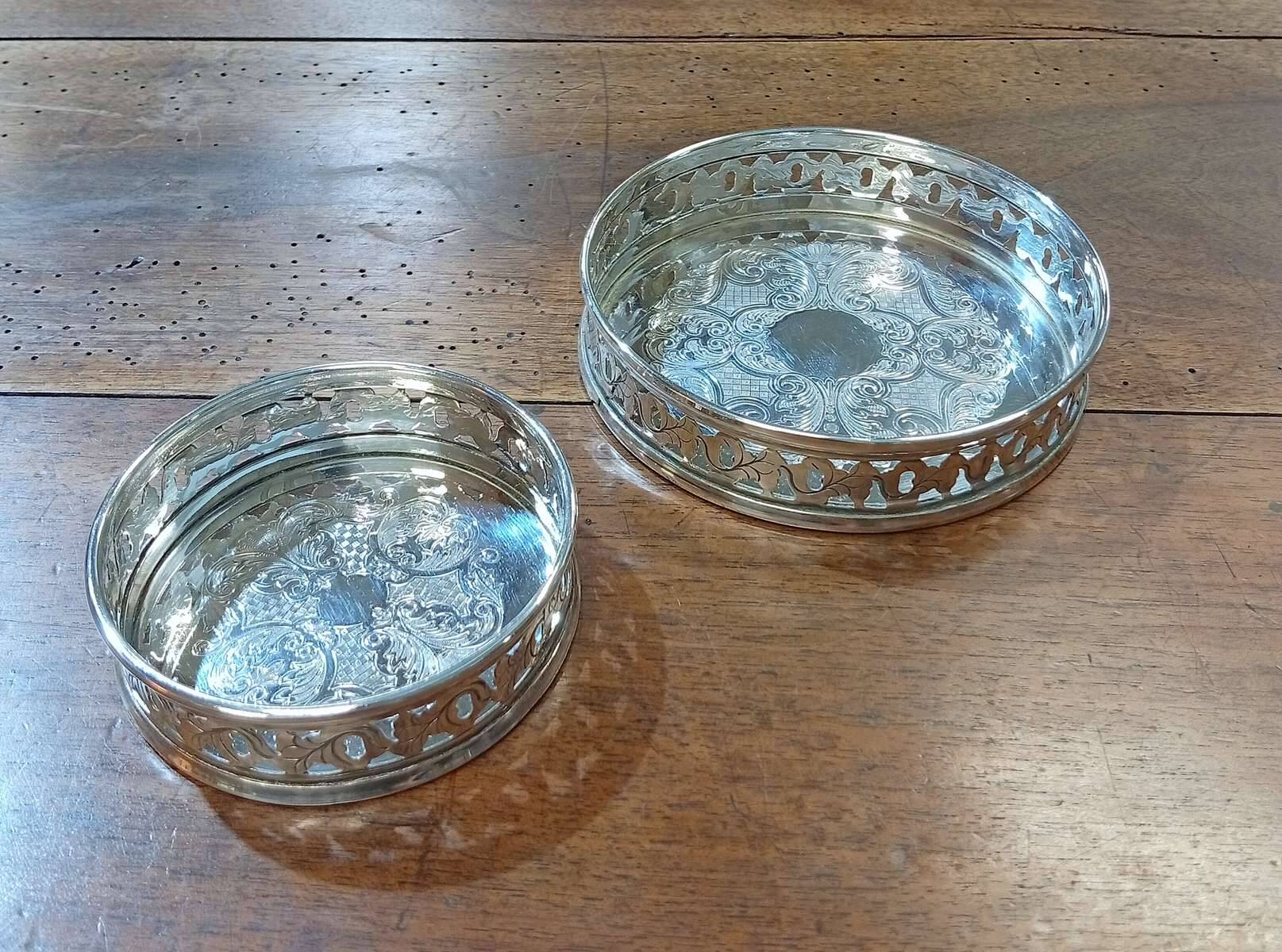 A pair of silver-plated bottle coasters for 75cl and 25cl.