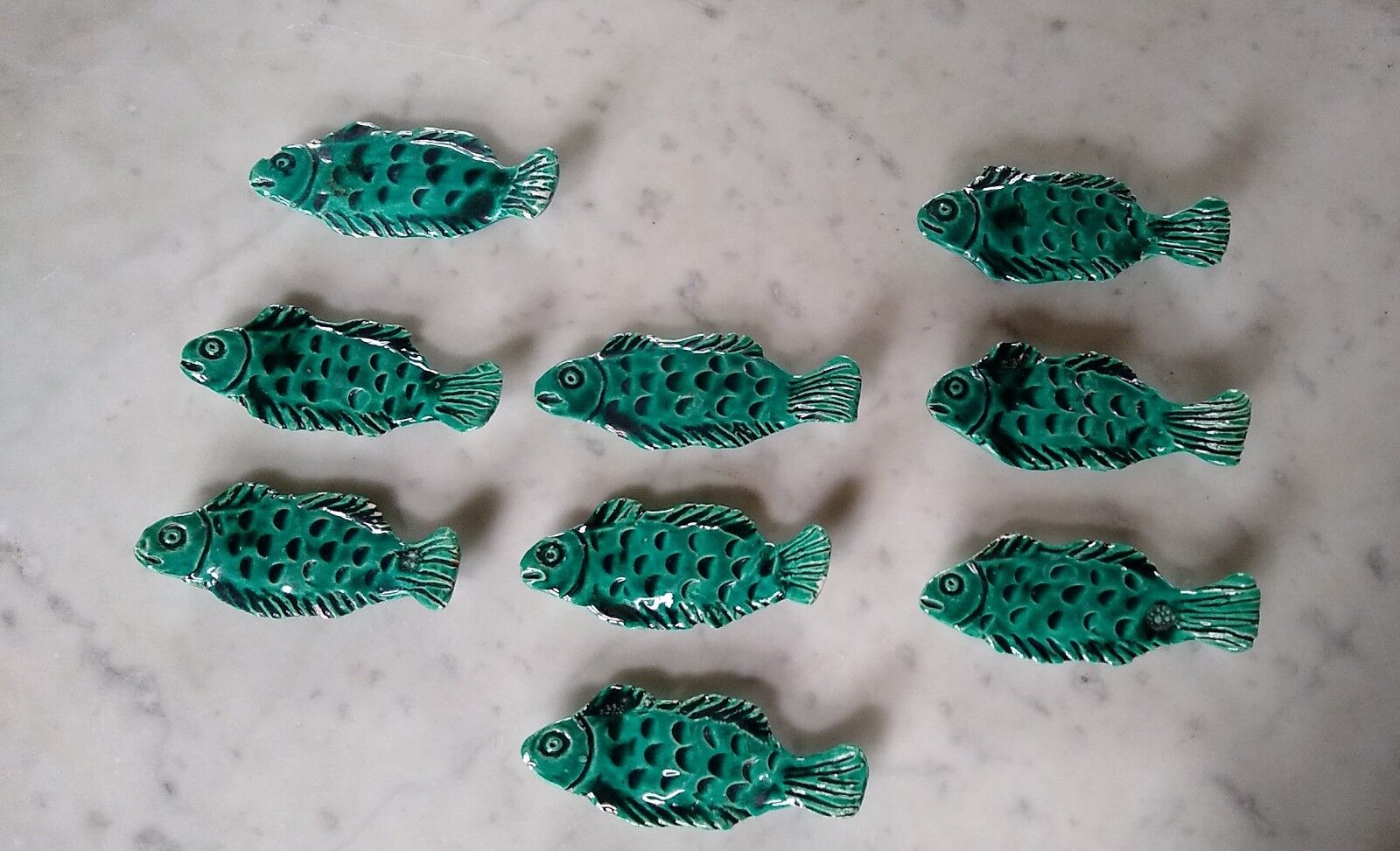 9 knife holders in green earthenware in the shape of a fish