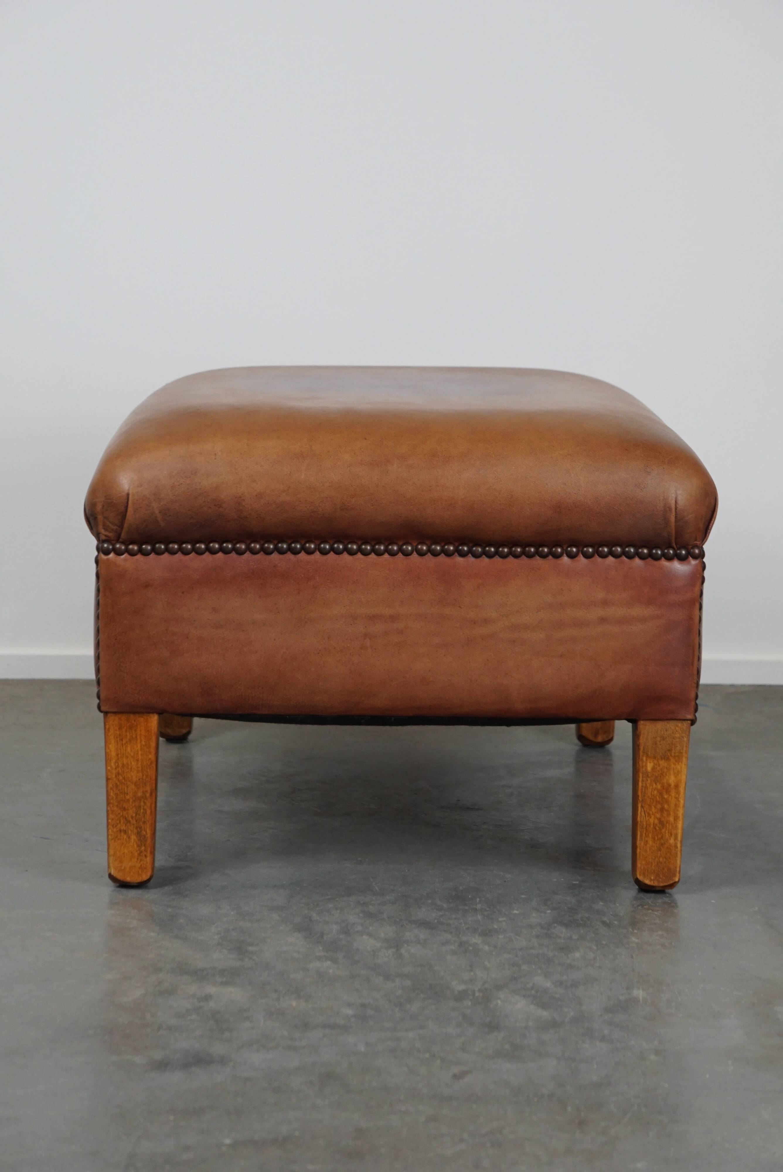 English-style leather ottoman in cognac-colored leather