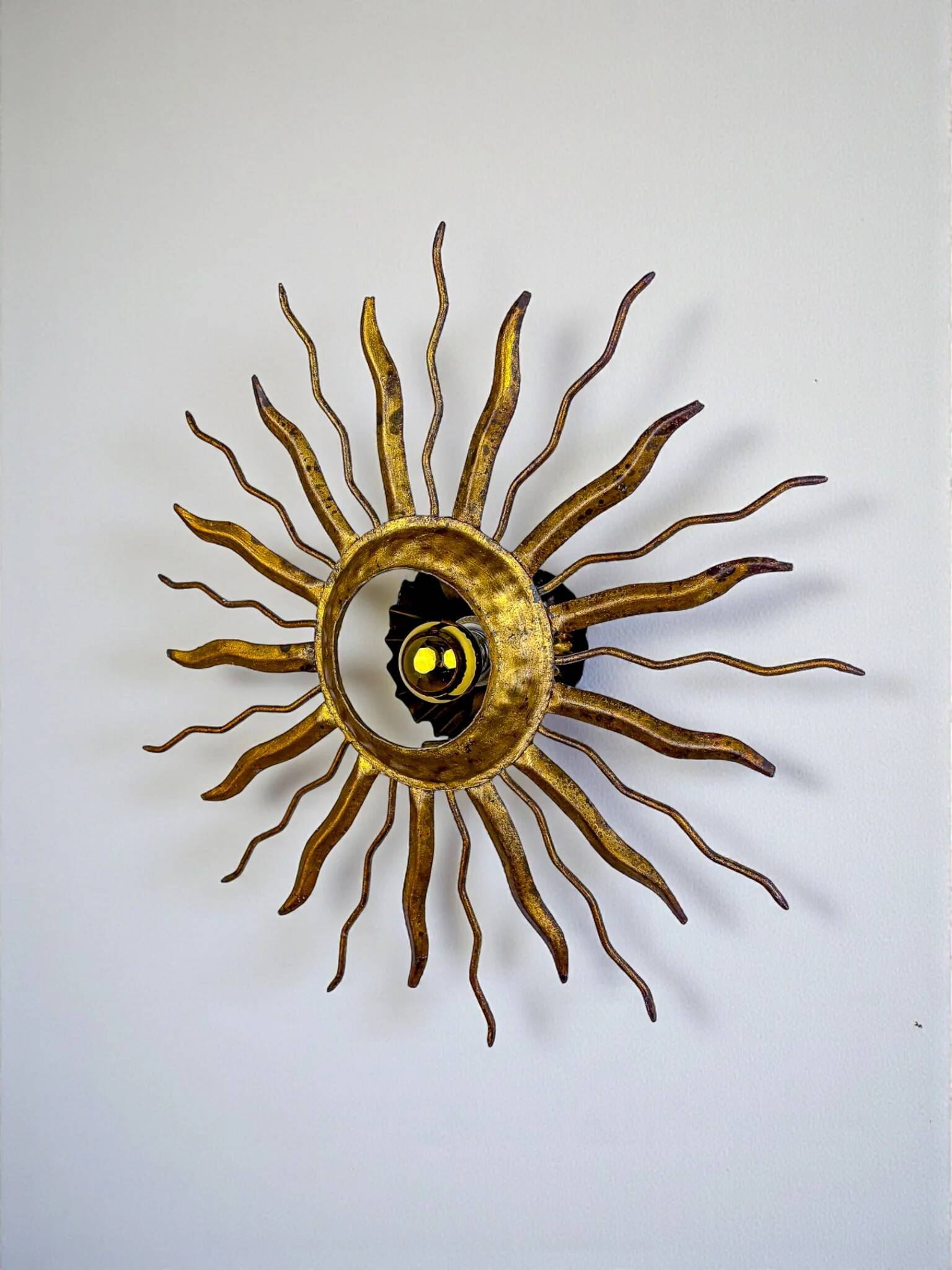 Brutalist sunburst ceiling light – gilt iron rays & exposed bulb, France, 1960s