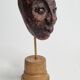 Expressive sculpted head in patinated terracotta on wooden base, 14 cm