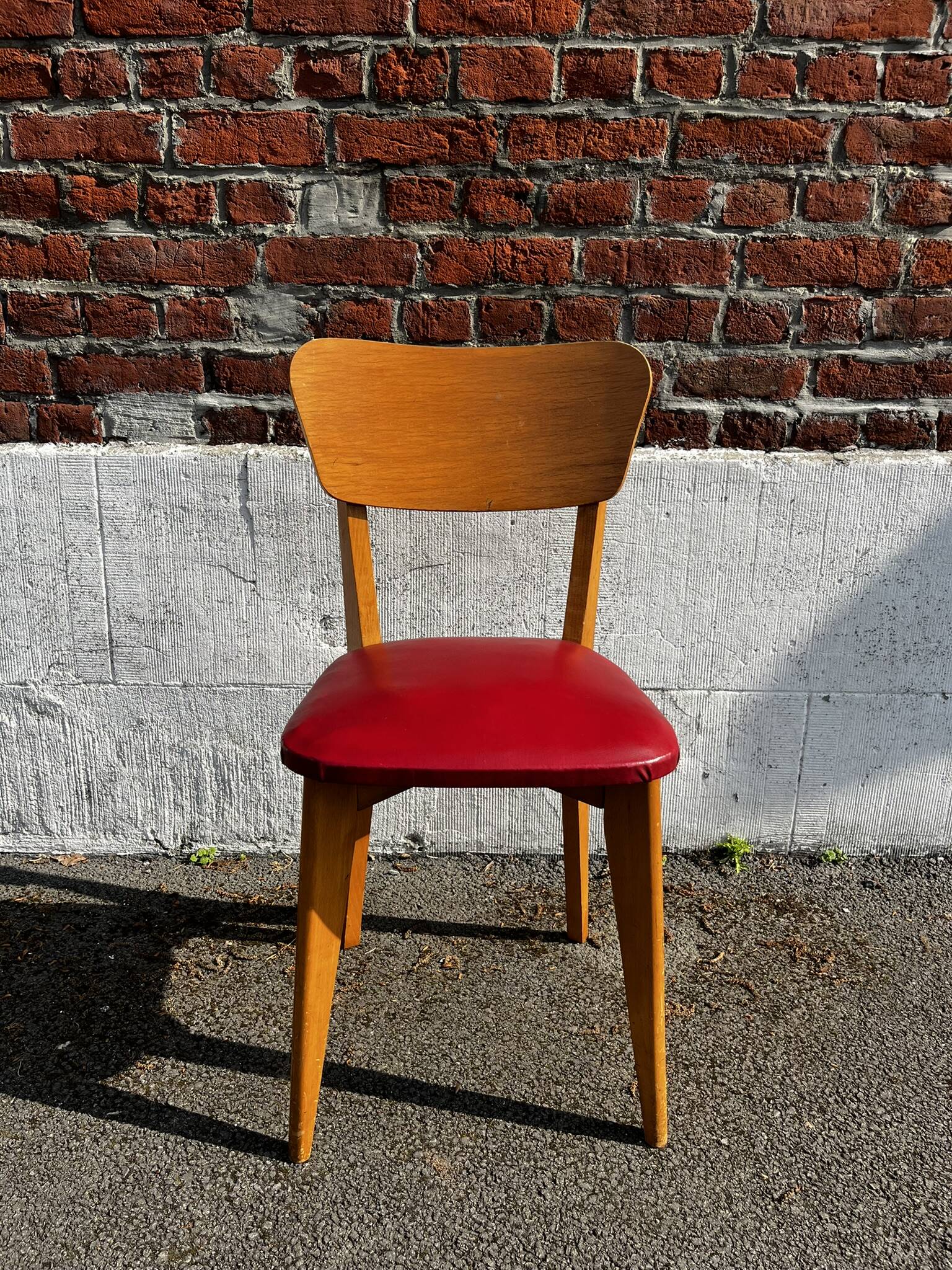 Set of 4 vintage bistro chairs in wood and red faux leather, with splayed legs.