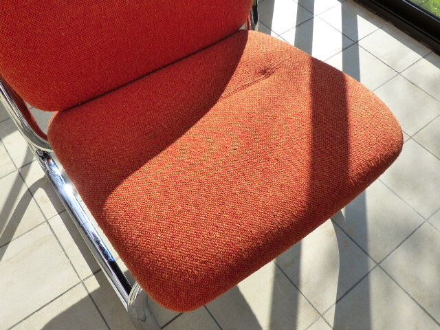 The 1970s orange armchair fabric and chrome metal