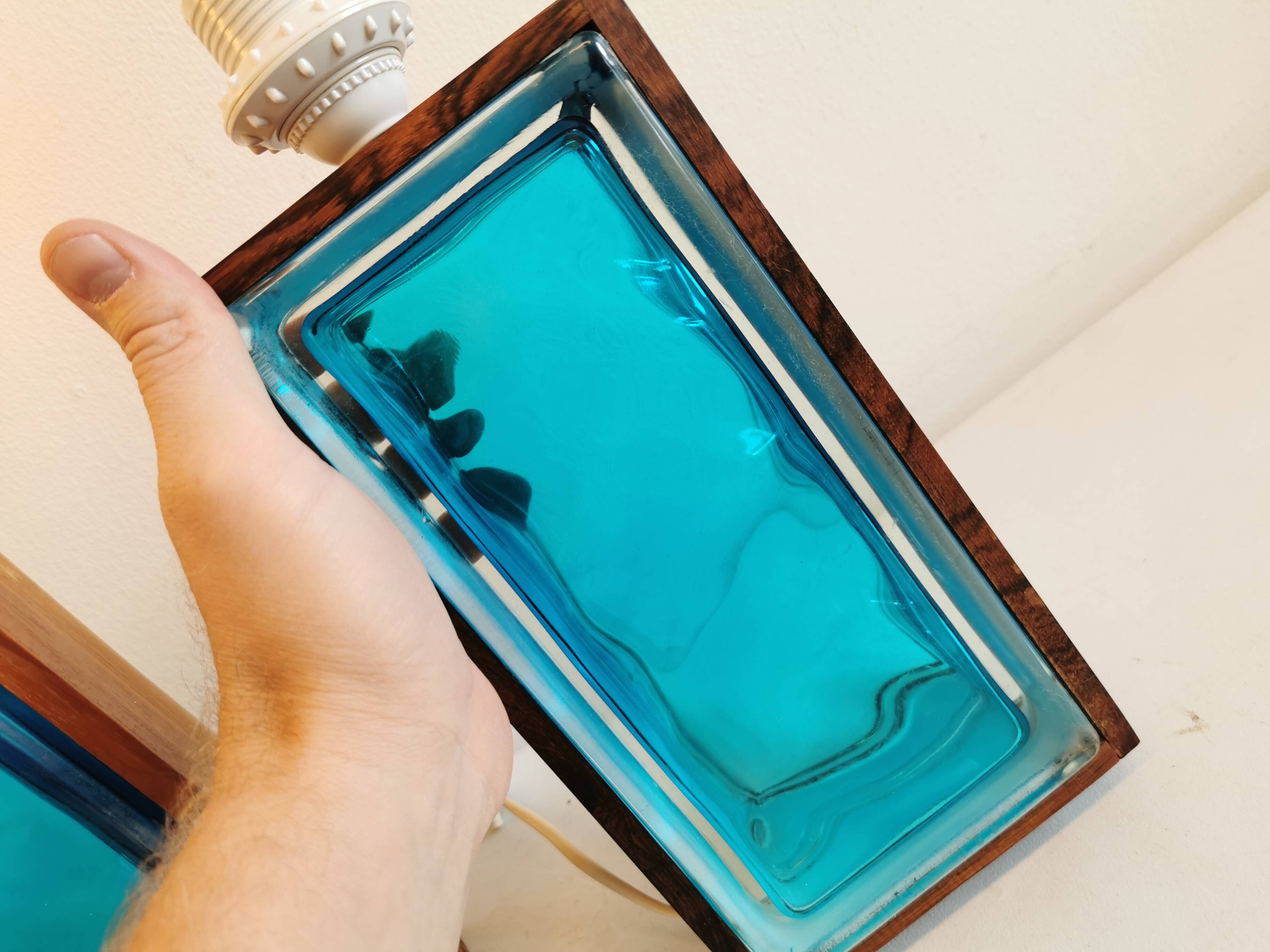 Two Swedish table lamps in solid pressed blue glass and teak wood "frame".