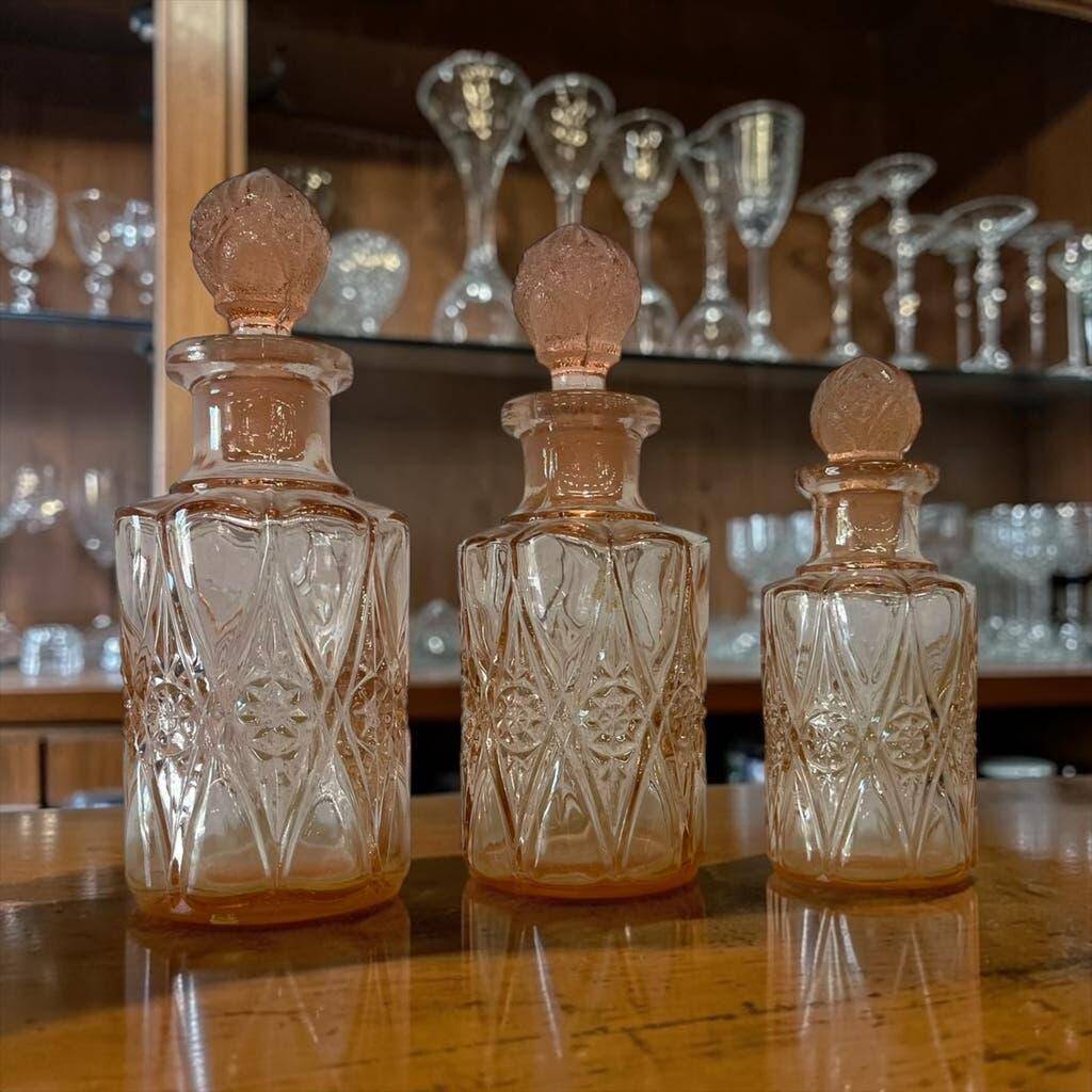 Set of 3 vintage pink glass bottles with corks.