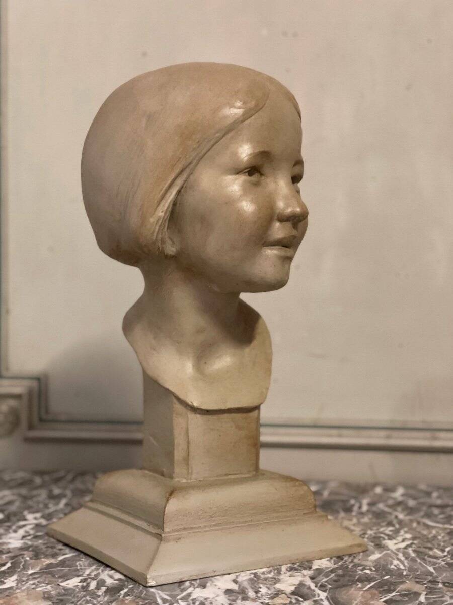 Plaster bust, young girl, monogram and date.