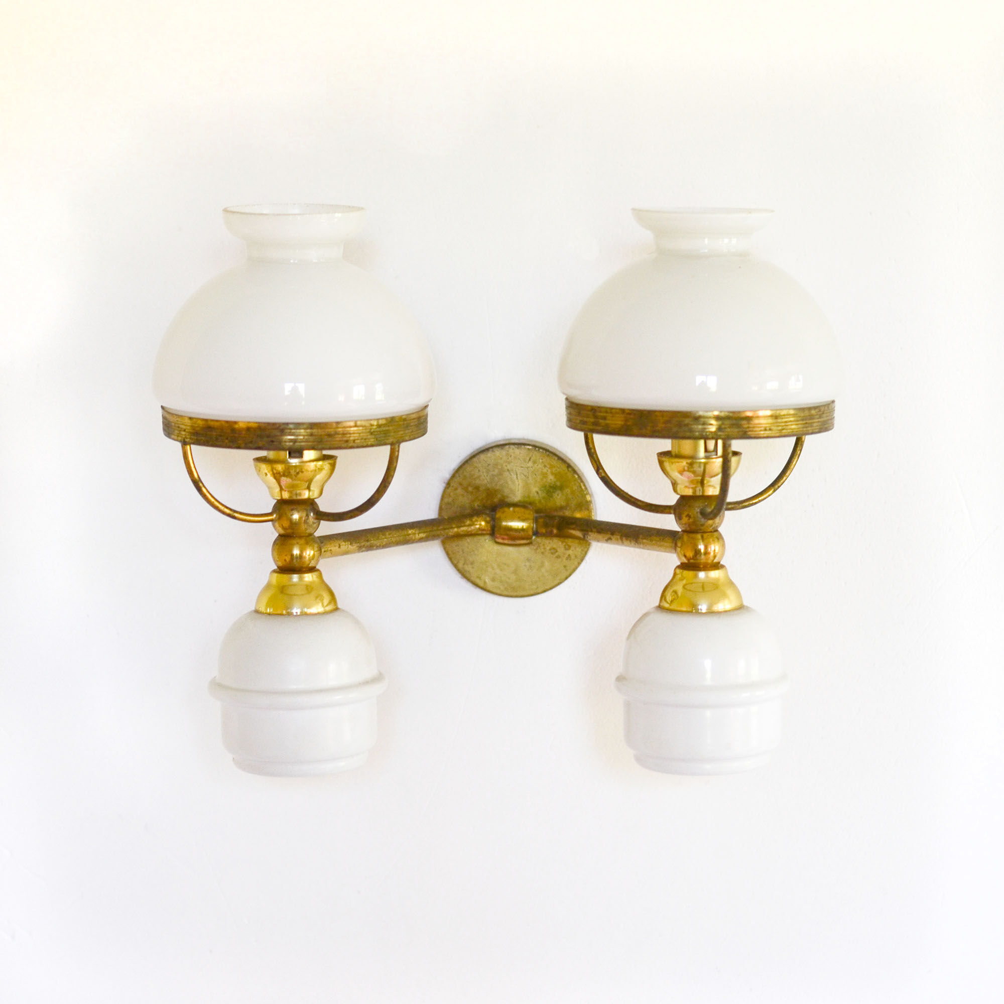 A double brass and opaline wall light