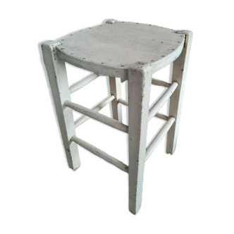 Vintage wooden stool with white peeling paint