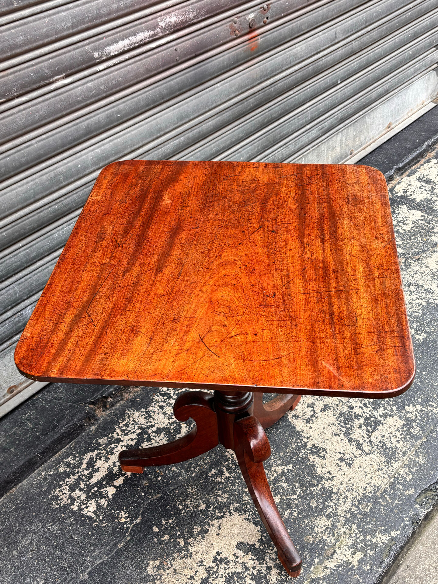 19th-century solid mahogany table with a tilting top and brass mechanism.