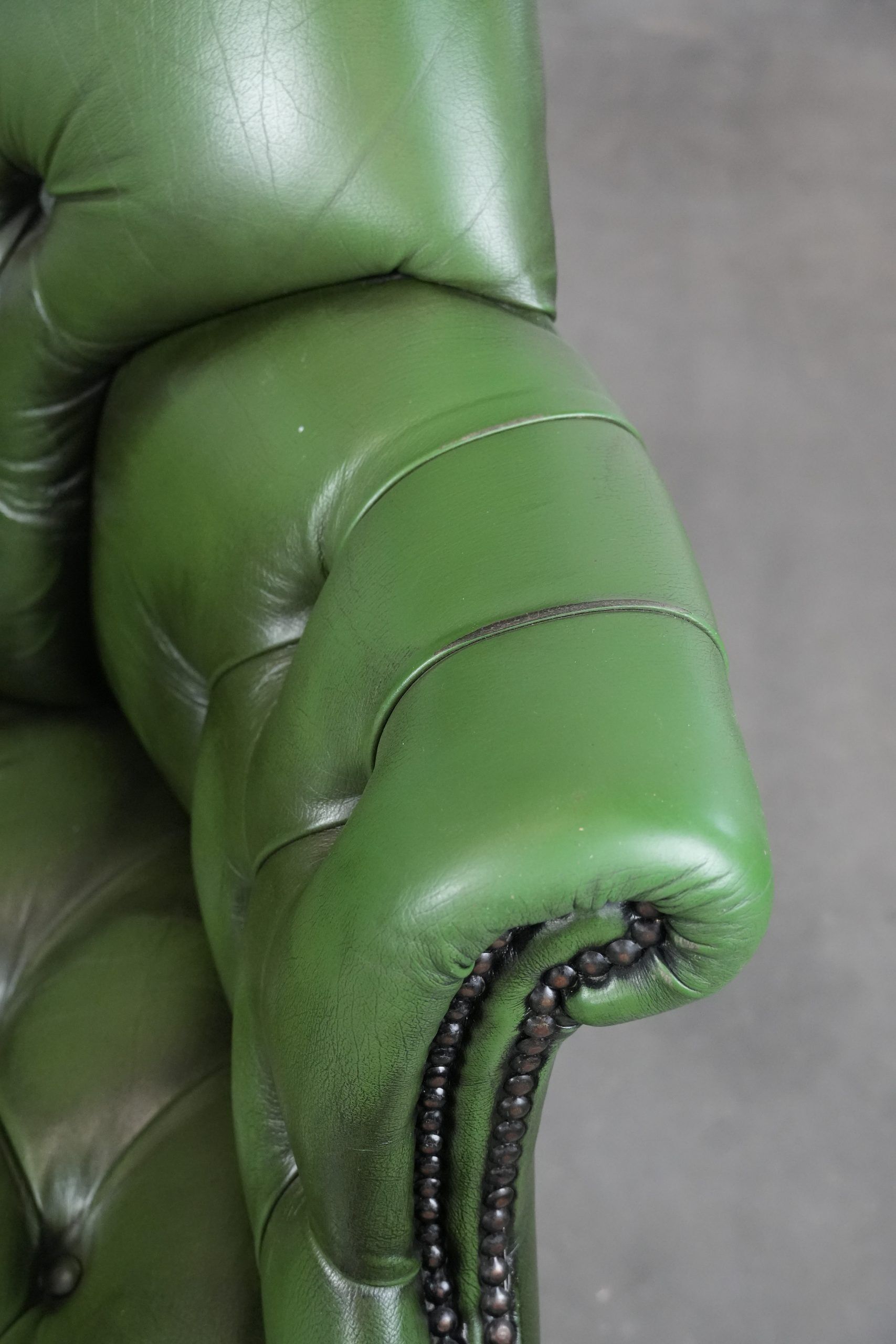 Large green cowhide Chesterfield office chair in English style on wheels
