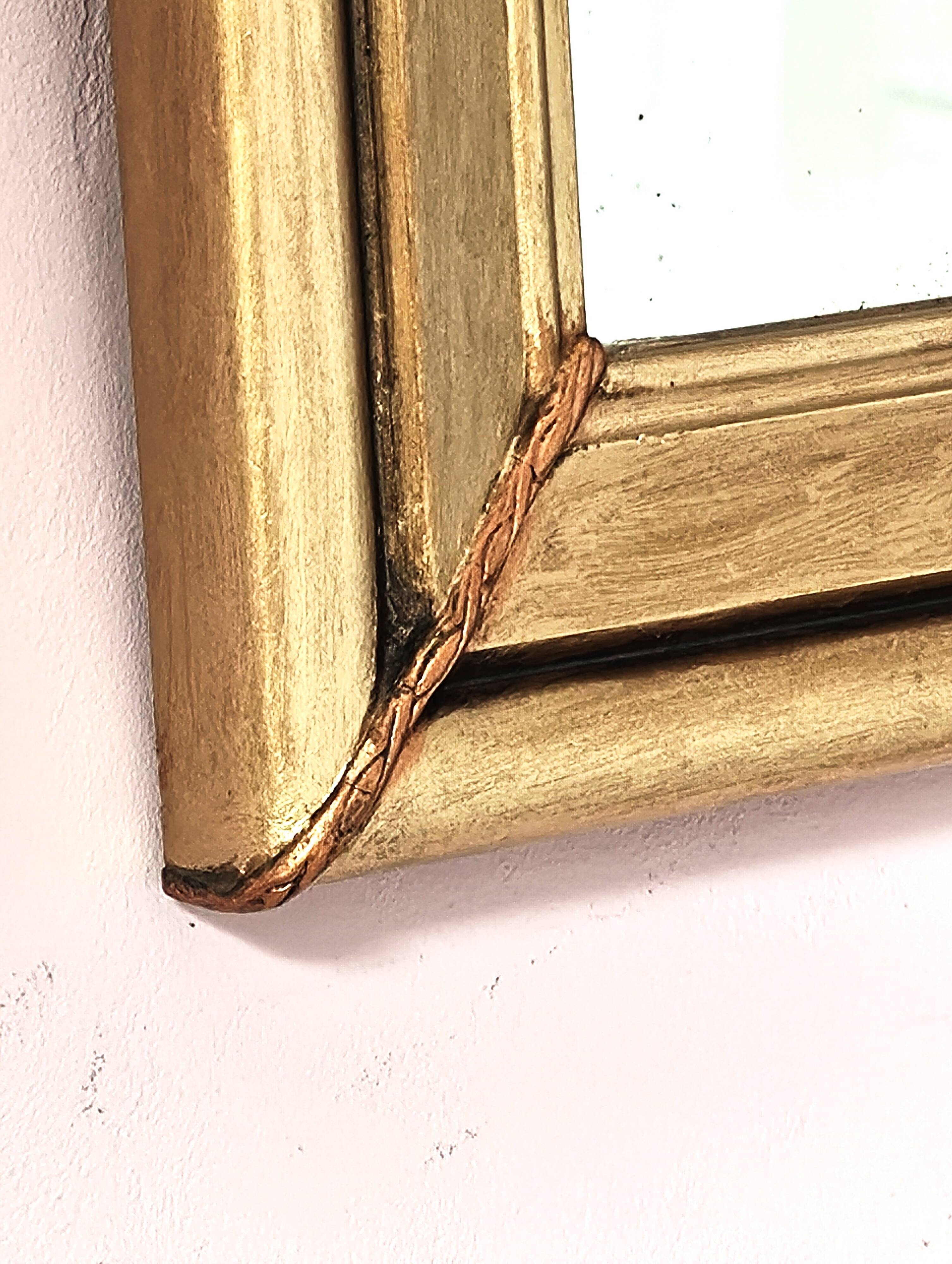 Art Deco mirror in gilded wood with curved floral decorations.