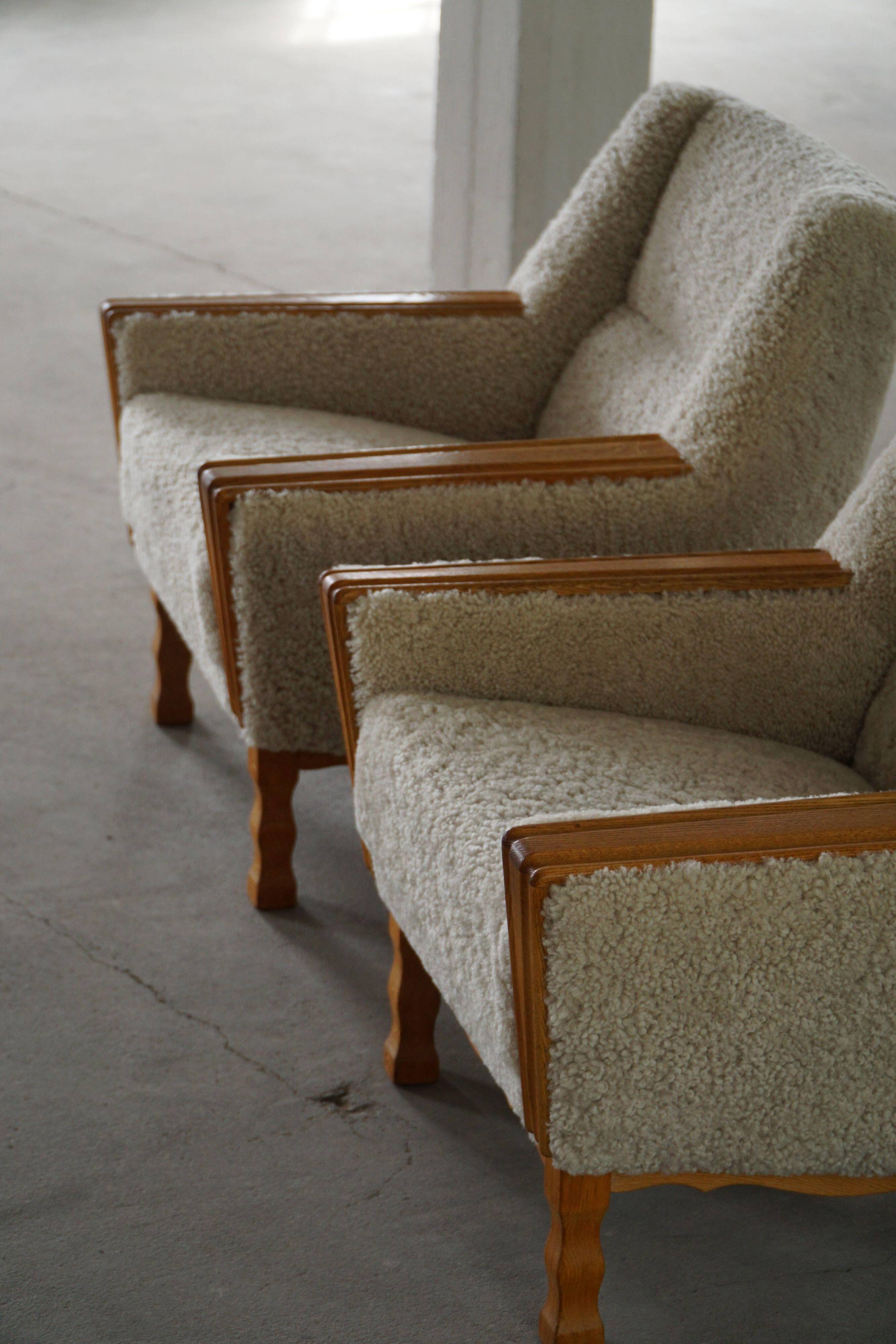 Modern Danish, a pair of easy chairs in oak and lamb's wool, Henning Kjærnulf, 1960s.