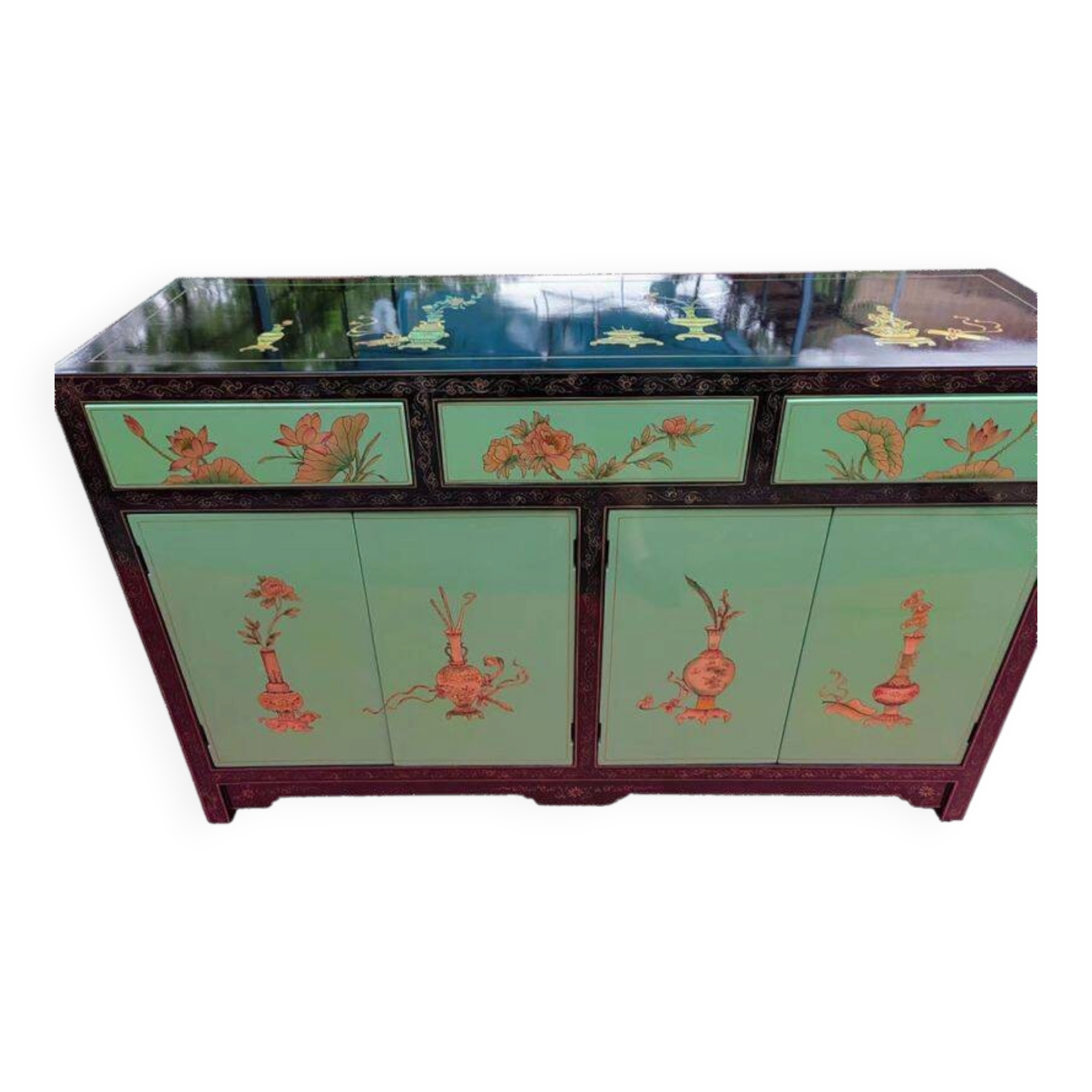 Lacquered buffet in soft green with floral patterns.