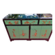Lacquered buffet in soft green with floral patterns.