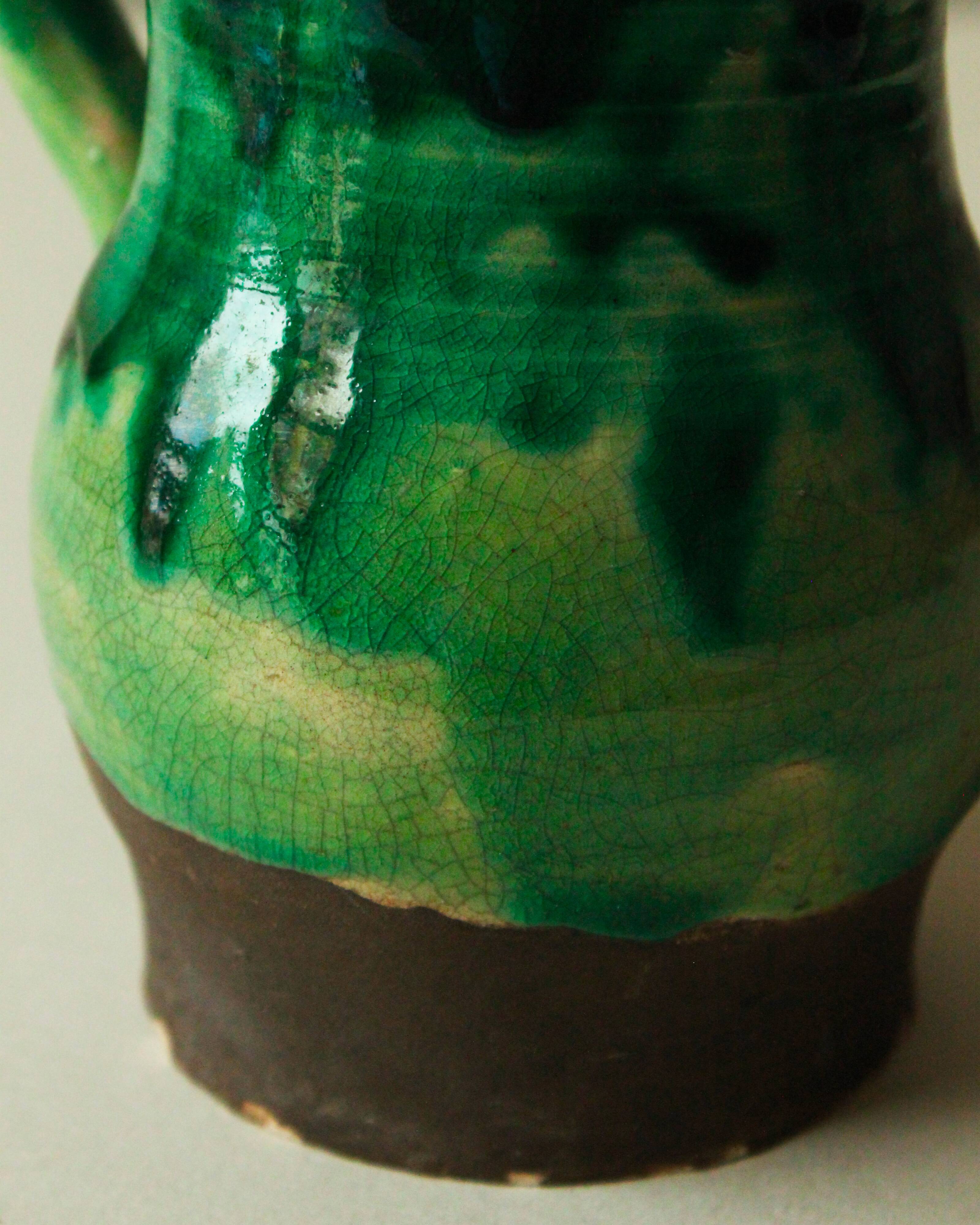 Glazed ceramic pitcher in green and brown by the potter Pierre Roulot.