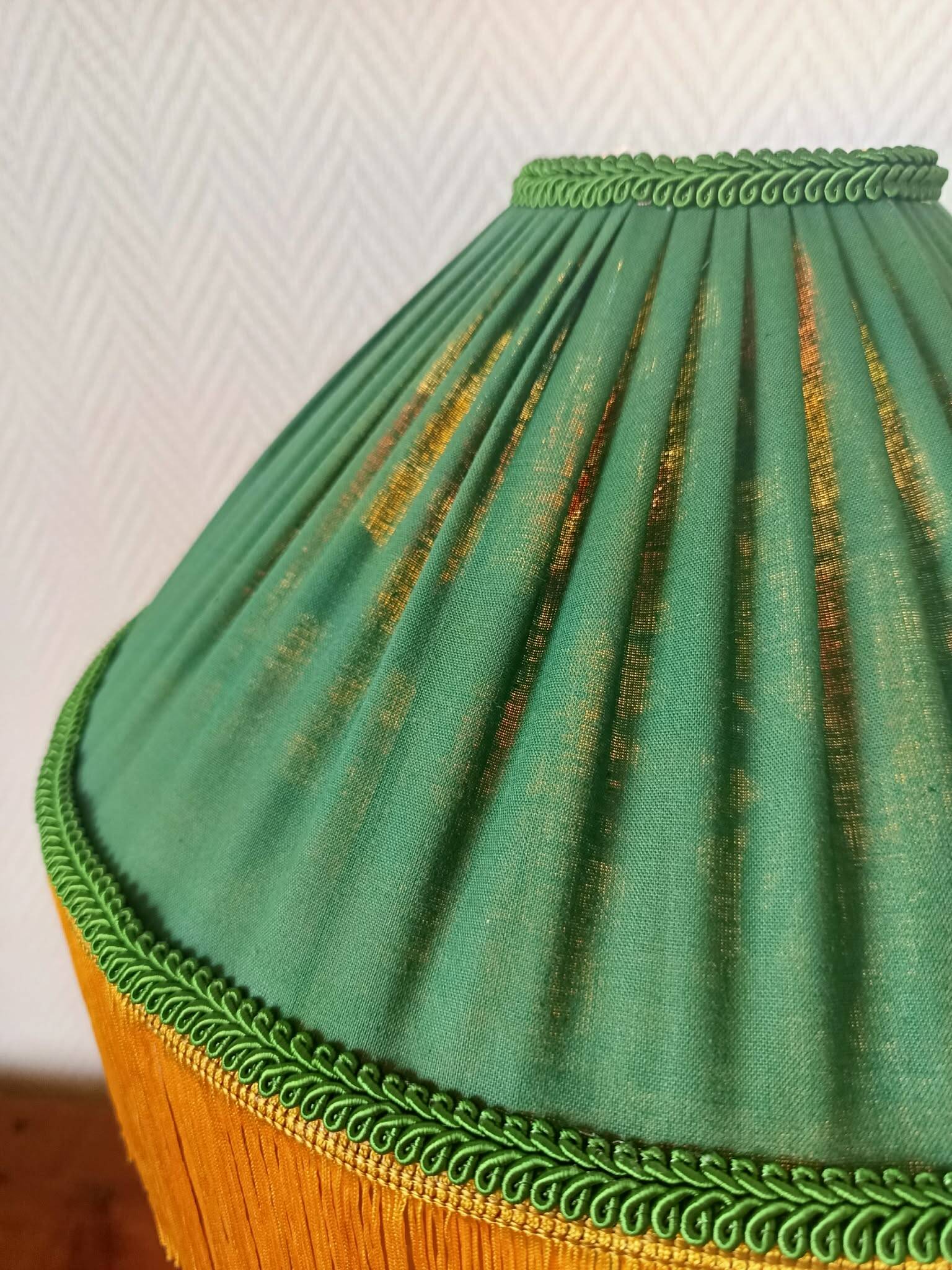 Green ceramic lamp with a vintage pleated fringe shade.