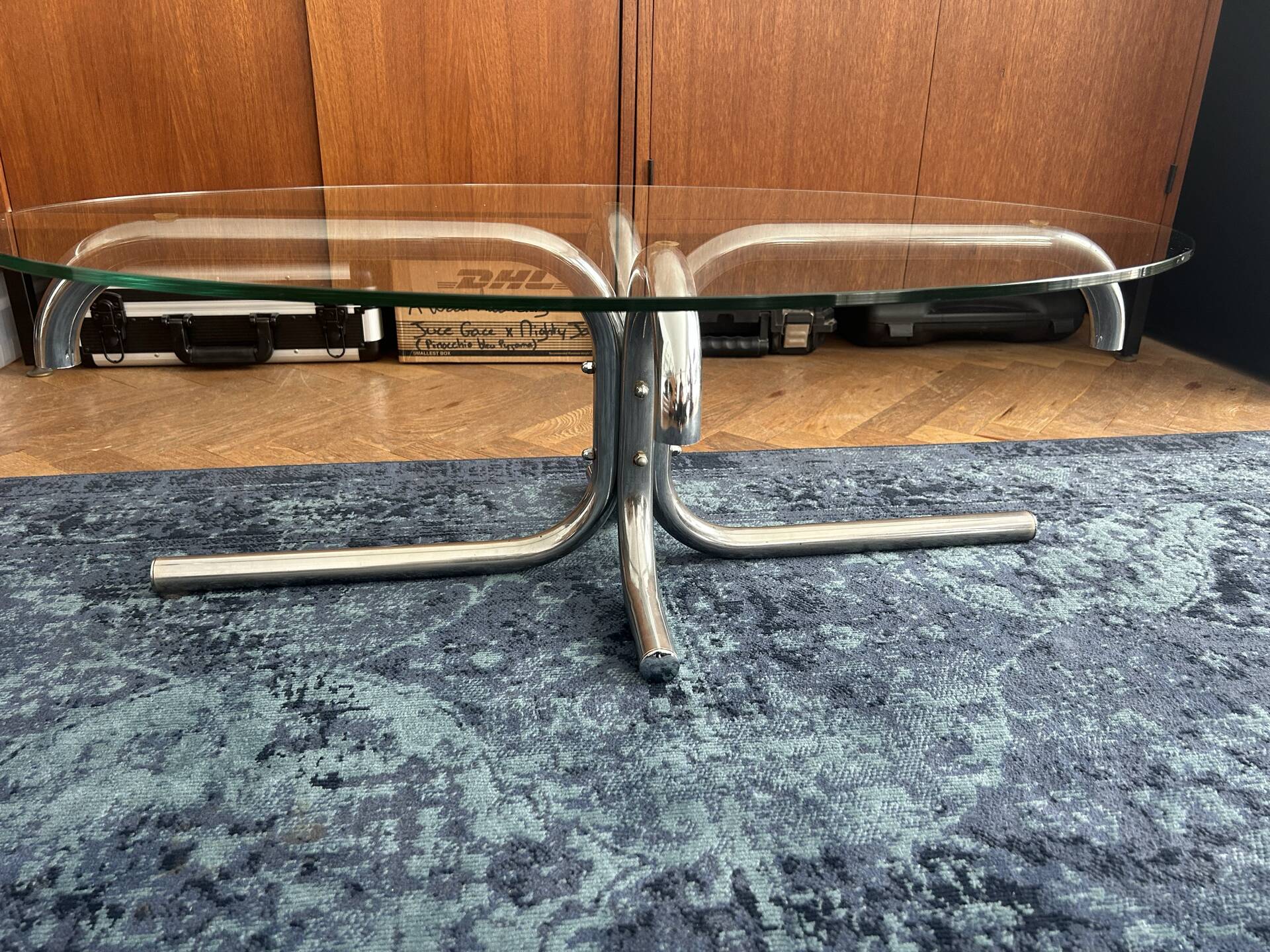 Oval glass coffee table with chrome legs, vintage 70s design.