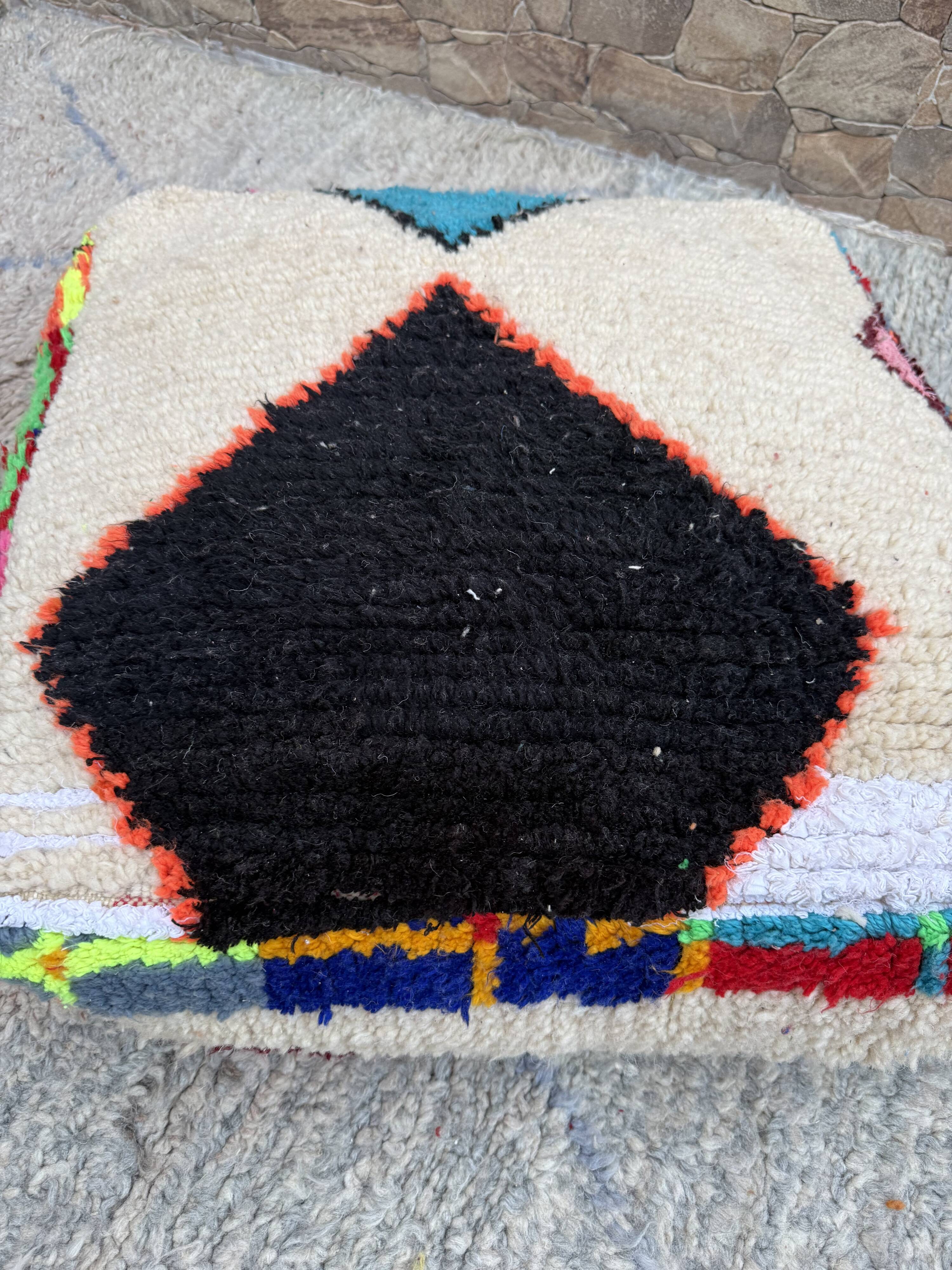 Berber floor pouf: Handwoven Moroccan wool cushion.