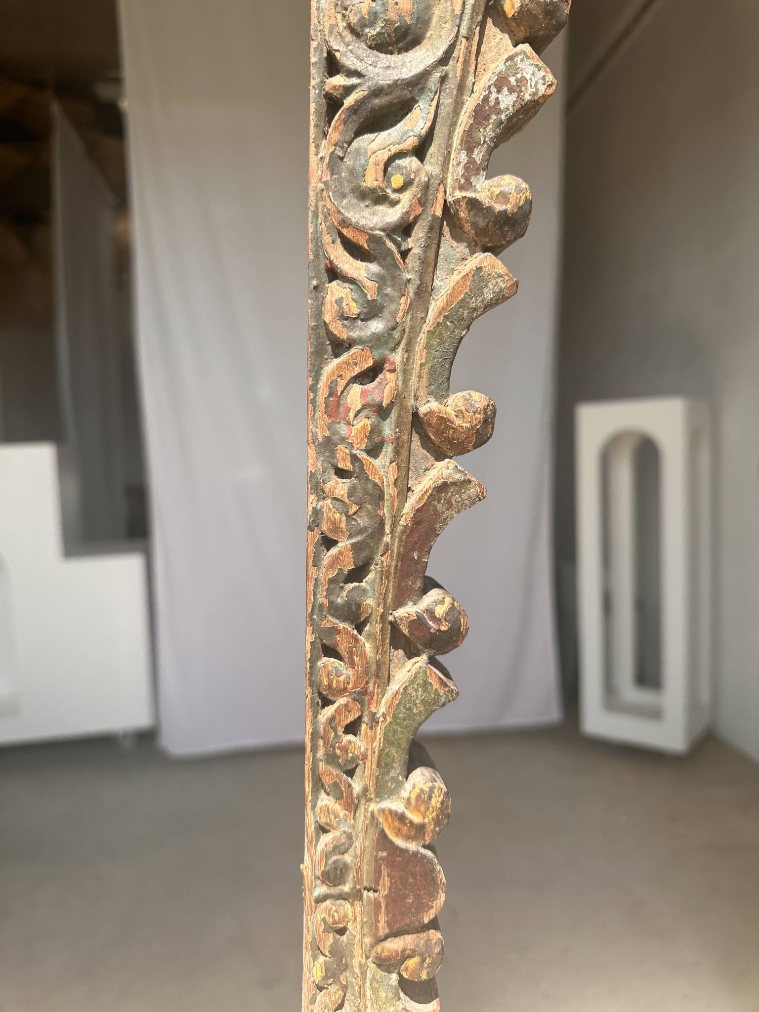 Indonesian construction element in carved wood with intertwined plant motifs mounted on a base (fri