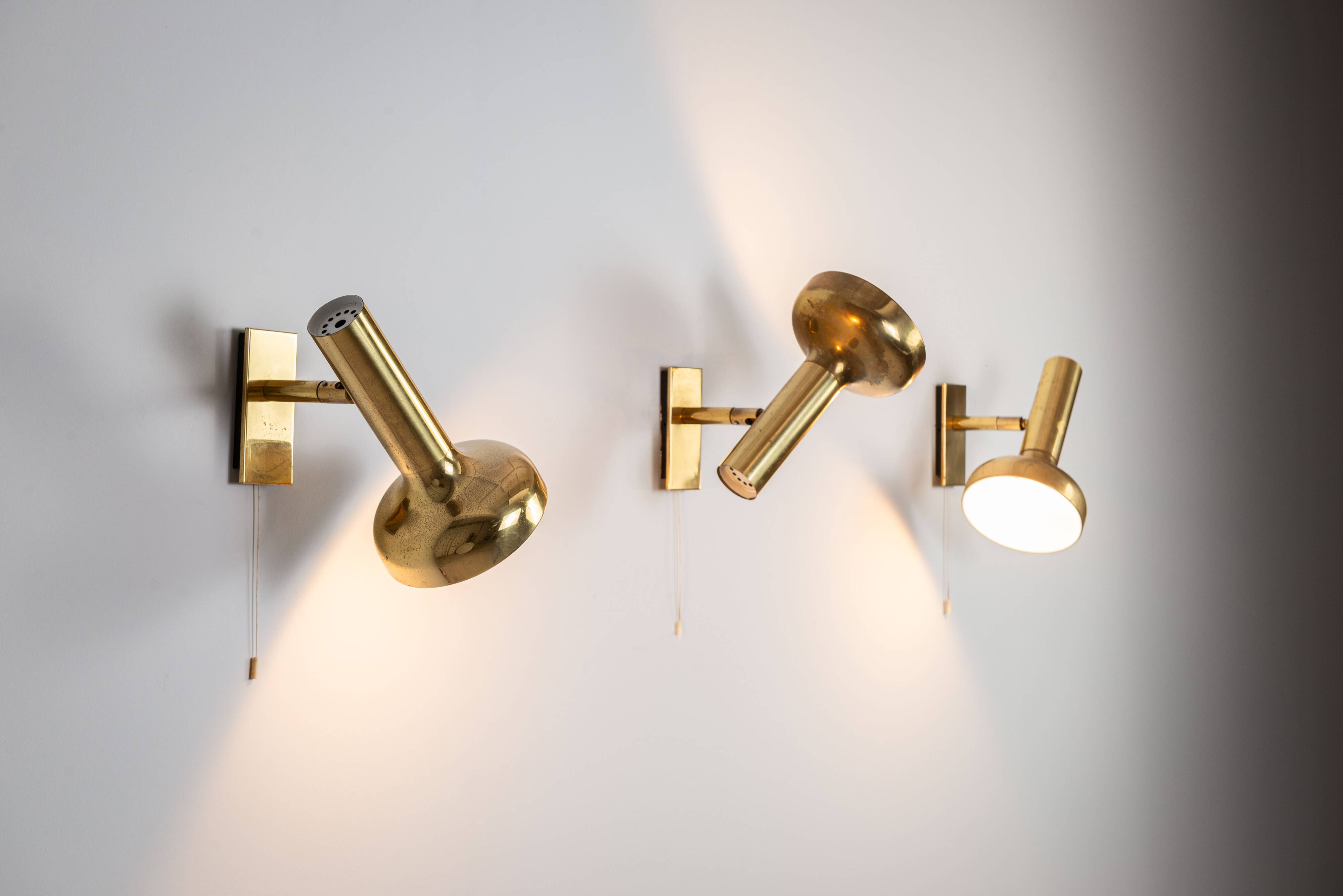 Set of three brass adjustable wall lamps