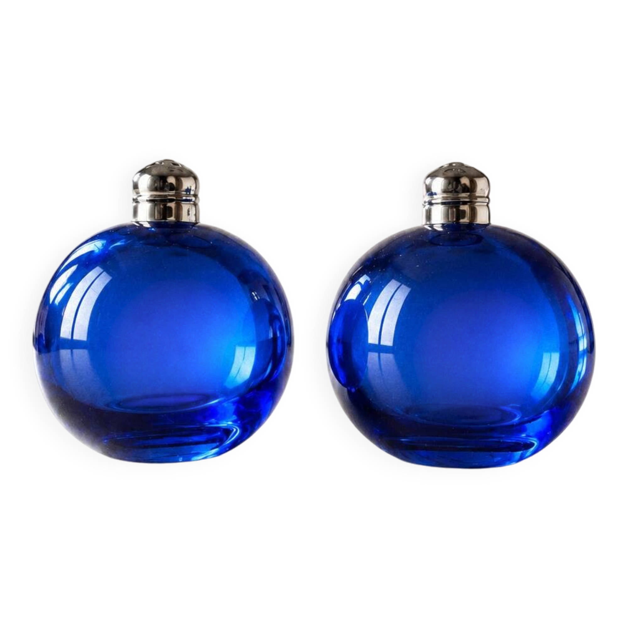 Bright blue glass salt and pepper shakers in a spherical shape.