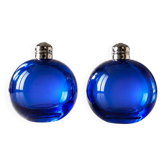 Bright blue glass salt and pepper shakers in a spherical shape.