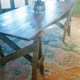 Table de ferme rustique patinée sur de lourds tréteaux