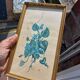 Decorative table with vintage blue flowers in a golden frame.
