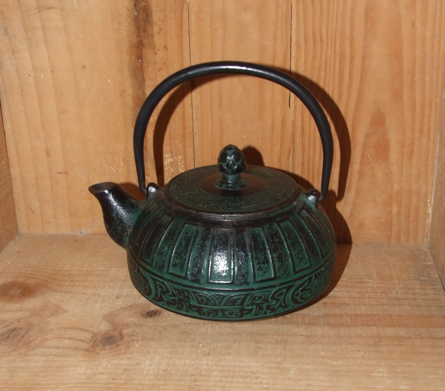 Japanese teapot in patinated green cast decorated with motifs