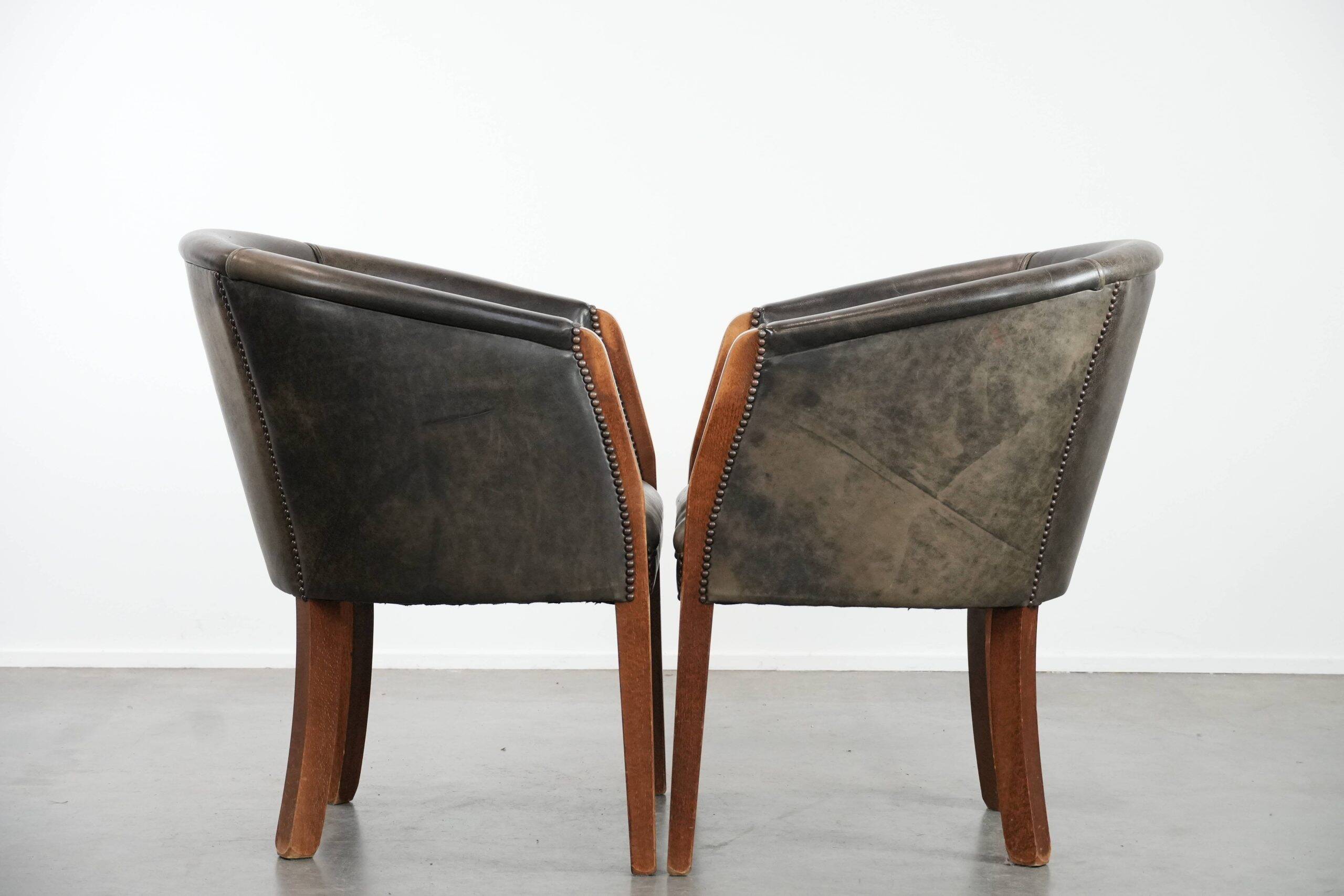 Set of two cowhide and wooden tub chairs with a sturdy colour scheme