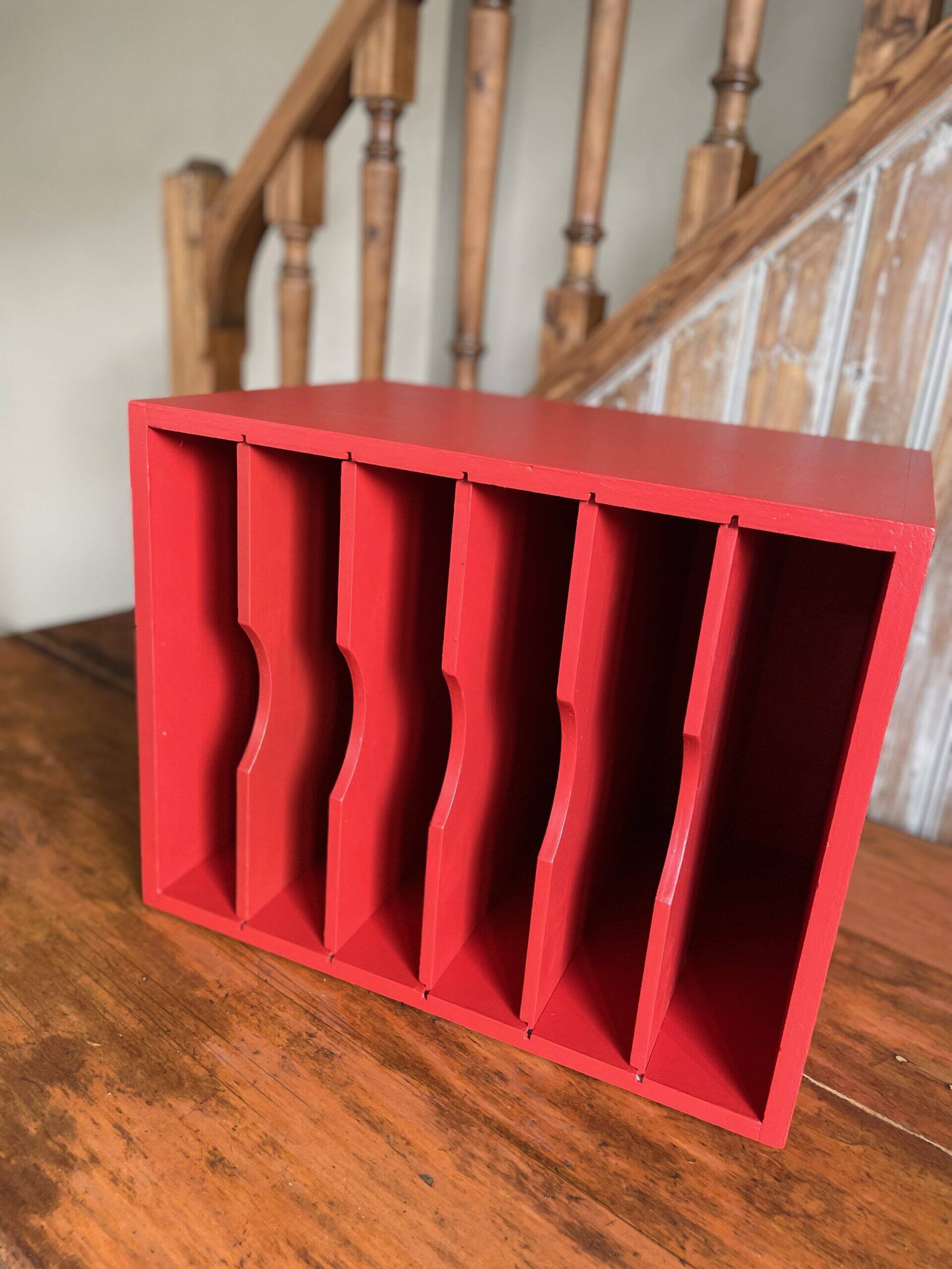 Vintage wooden magazine rack in red.
